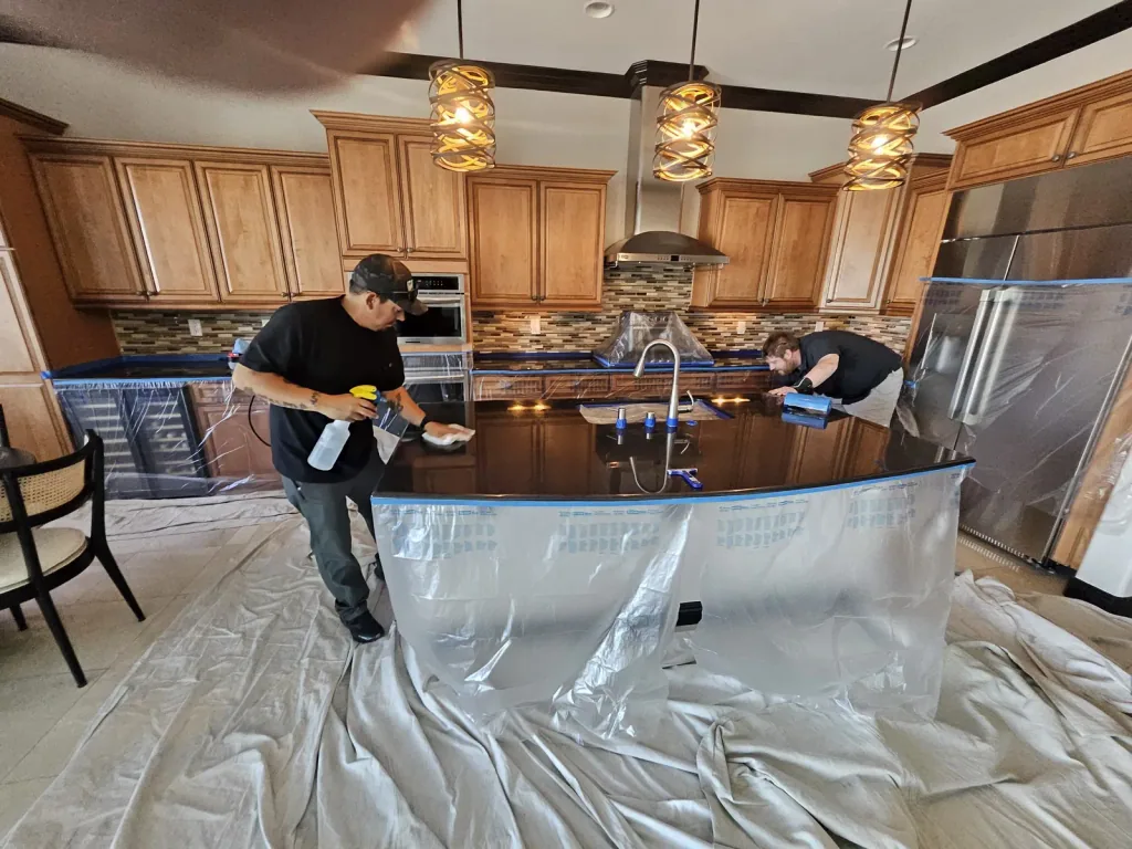 Technicians cleaning and polishing a protected granite kitchen island