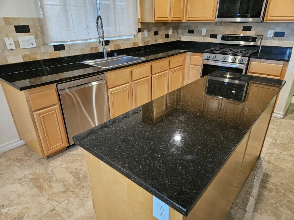 Dark granite kitchen island with an even, reflective polished finish