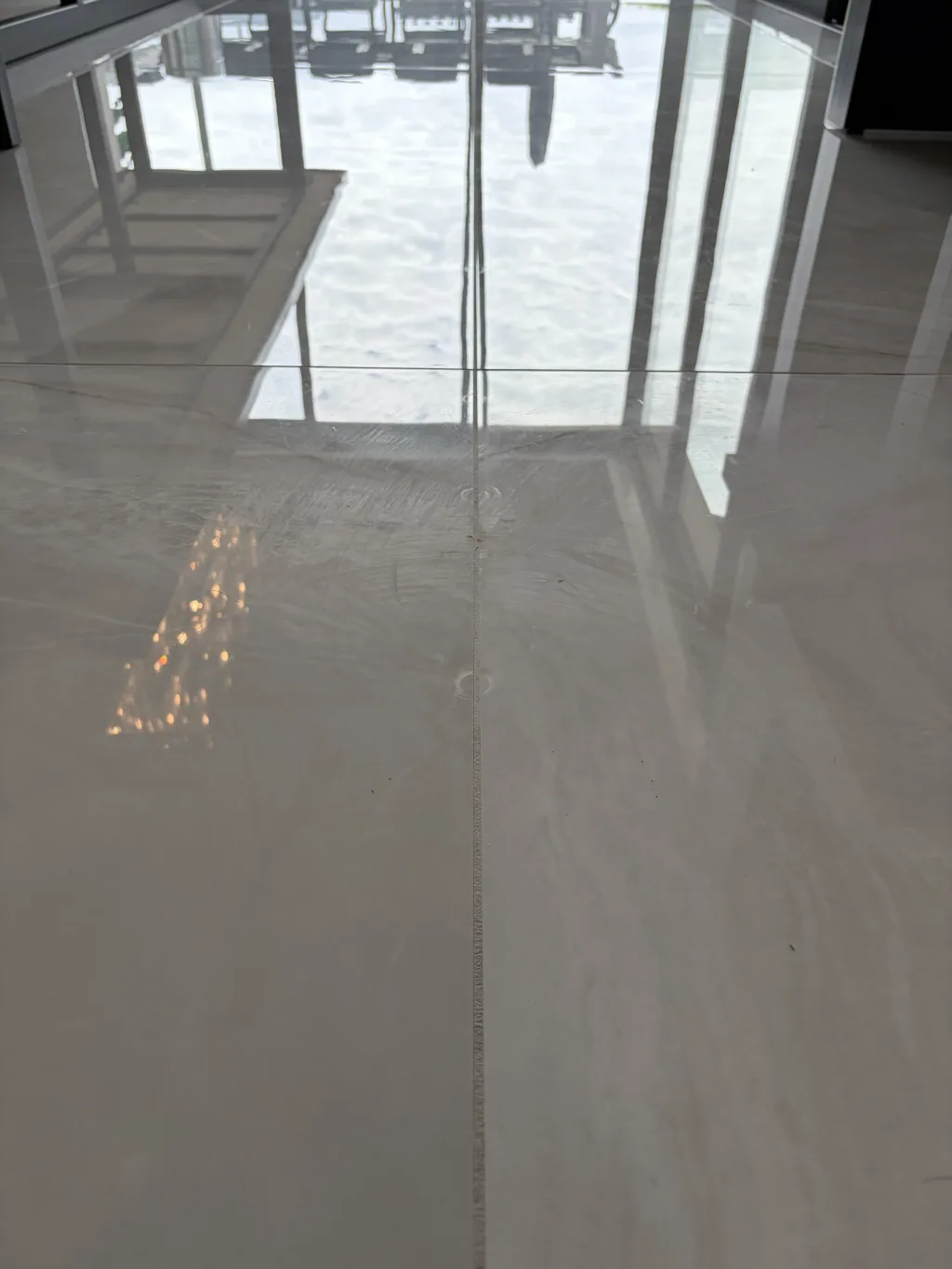 Close view of a marble floor surface showing veining, reflected light, and surface detail