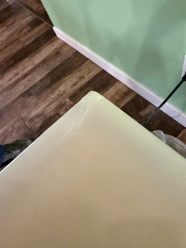 Rebuilt corner of a pale marble dining table seen from above, with a clean square edge