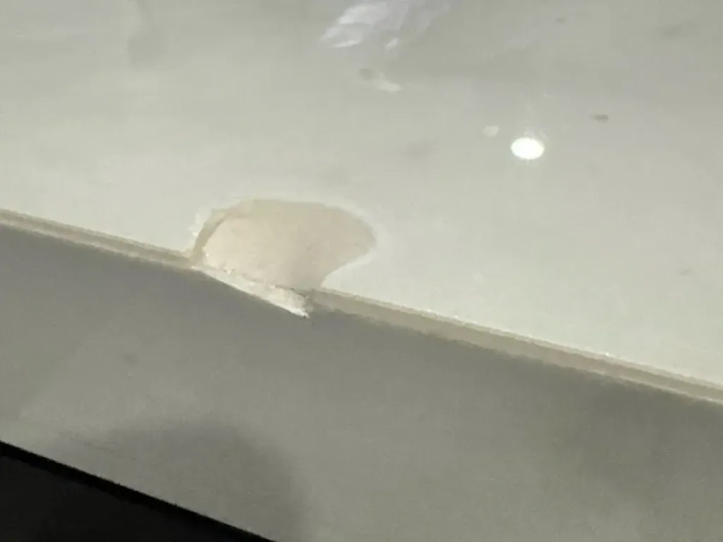 Chip broken out of the front edge of a white quartz countertop