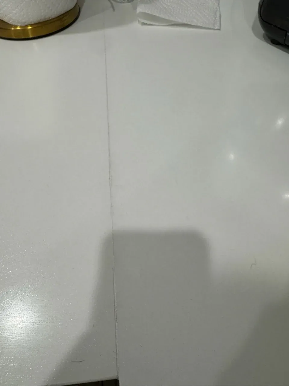 Seam between two white quartz slabs, opening slightly at the front edge
