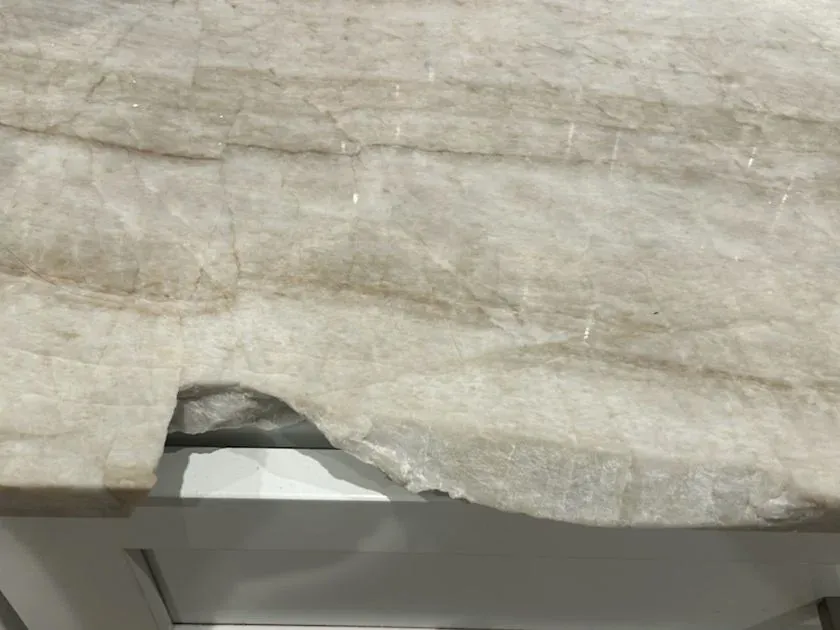 Large piece broken out of the edge of a veined quartzite countertop