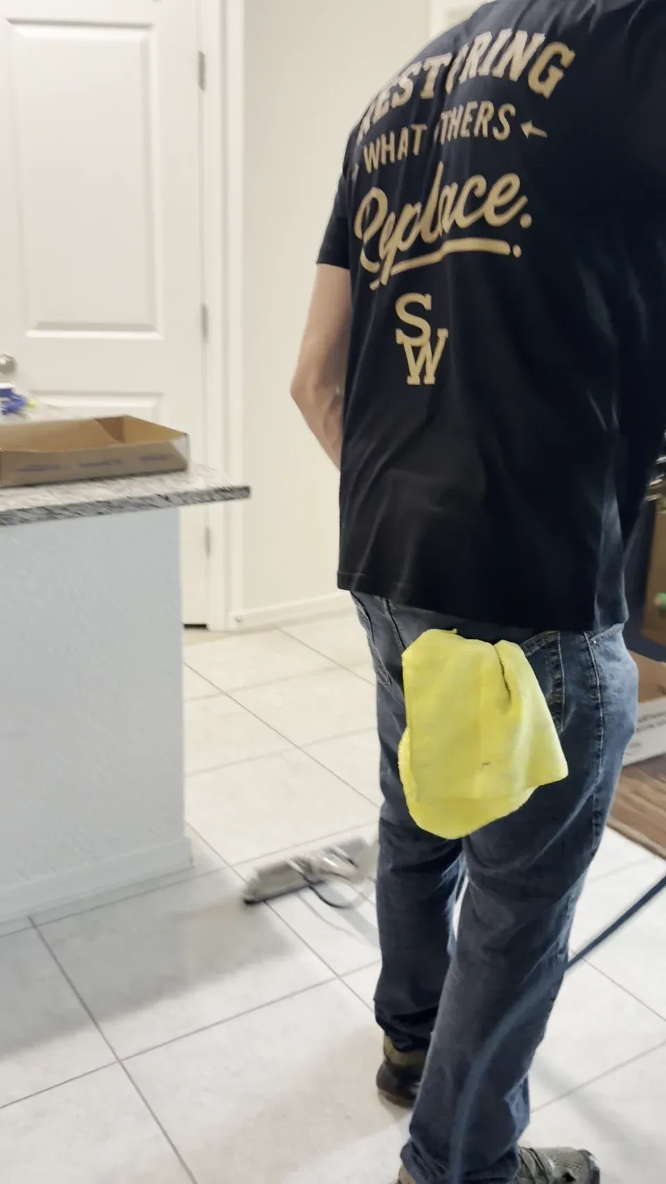 The back of Justin’s Stain Wranglers shirt, reading Restoring What Others Replace above the SW monogram