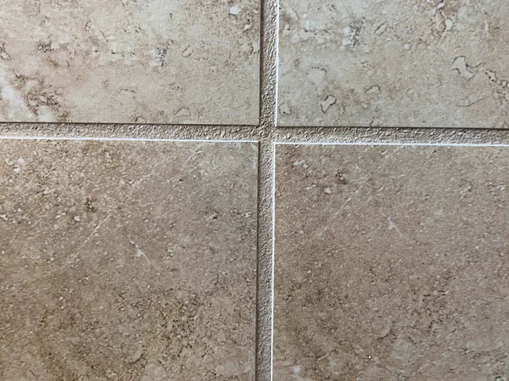 Travertine floor tile with evenly colored grout joints after color sealing