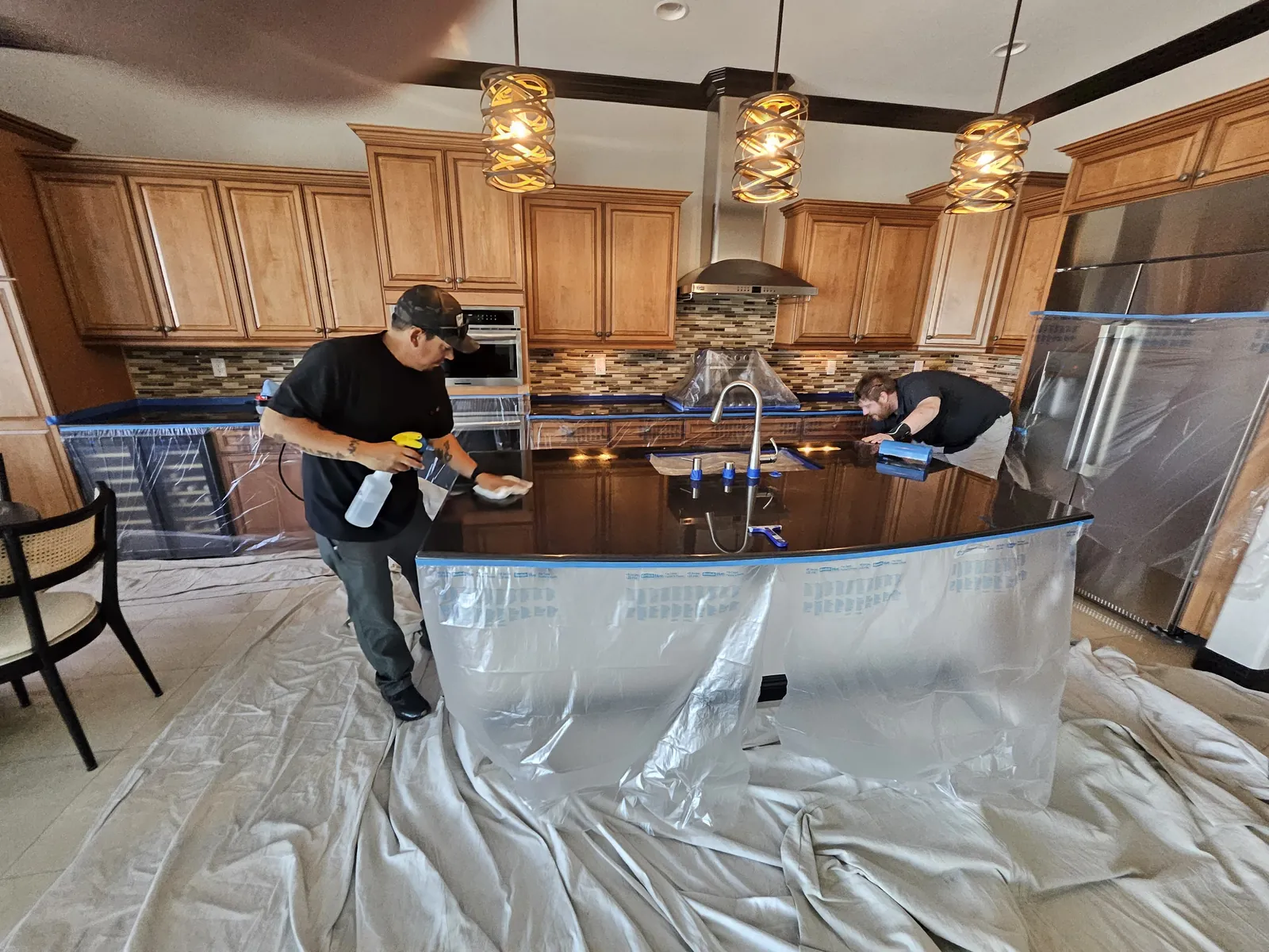 Technicians cleaning and polishing a protected granite kitchen island