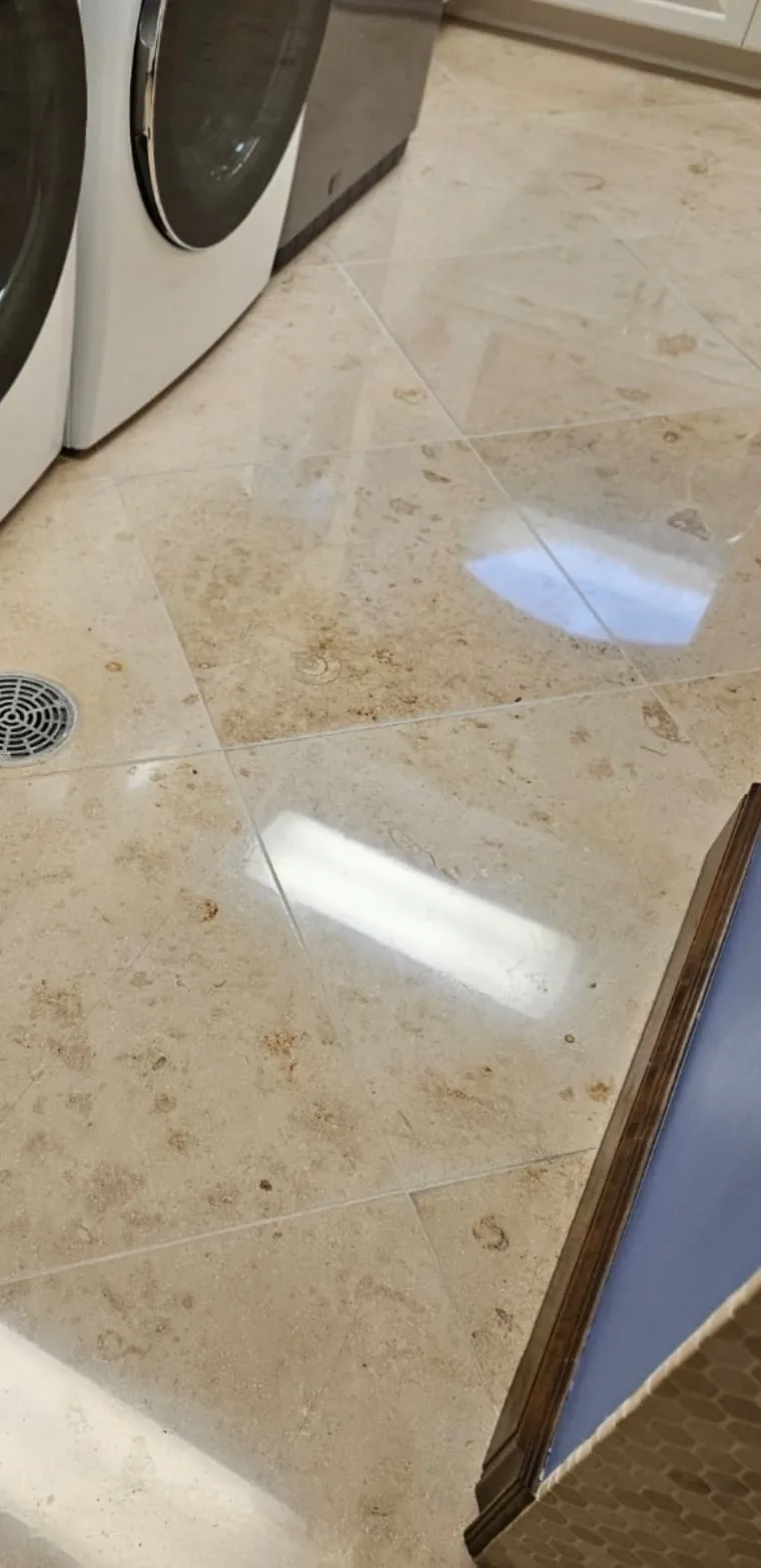 The same limestone floor after honing and polishing, now reflecting the window light