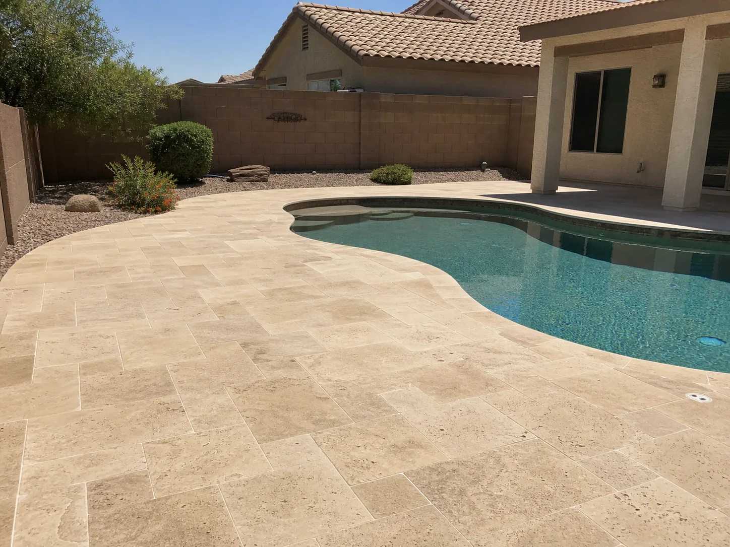 Representative Arizona backyard with a naturally finished travertine pool deck