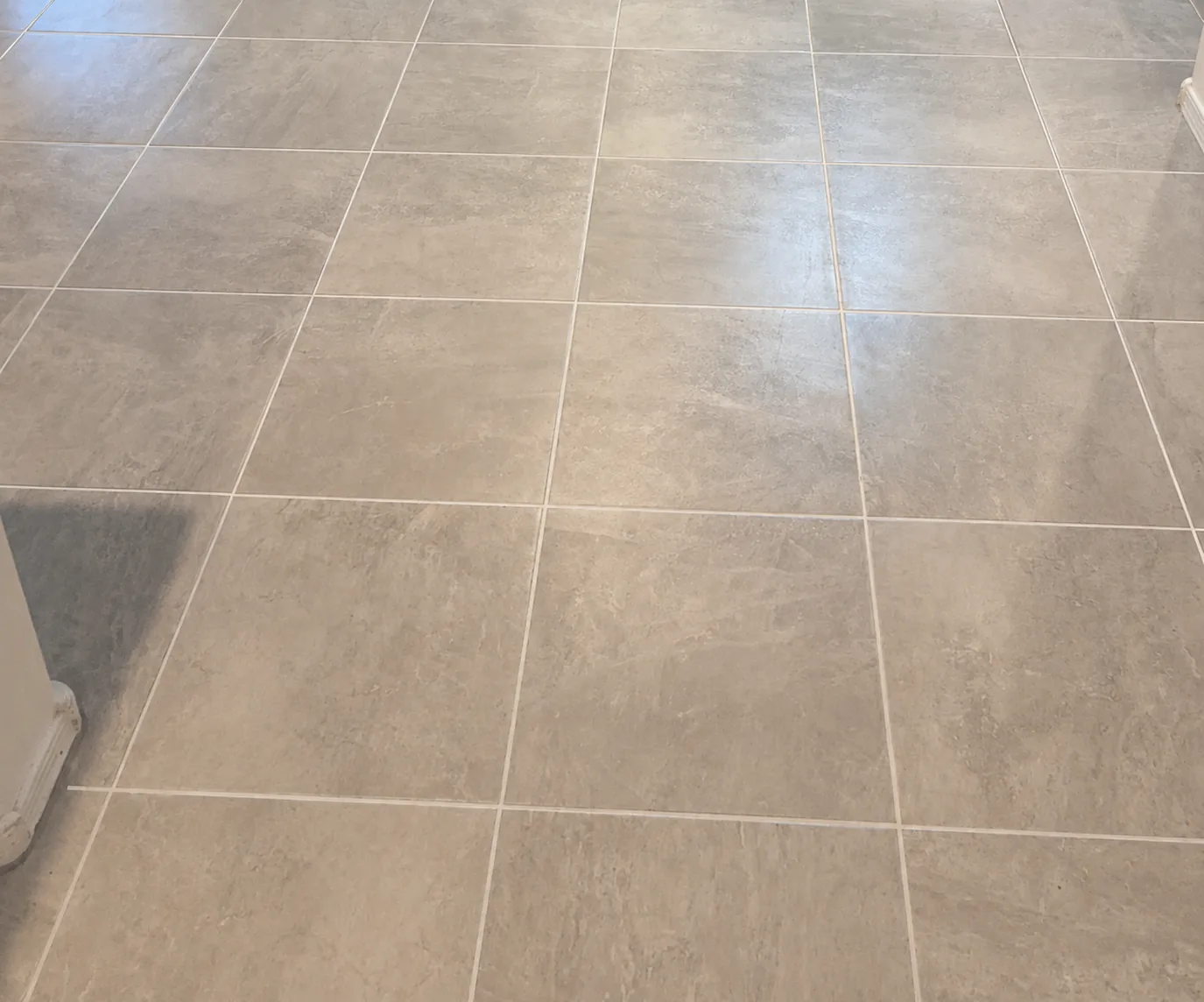 Large format tile floor with clean, evenly toned grout joints after cleaning and sealing