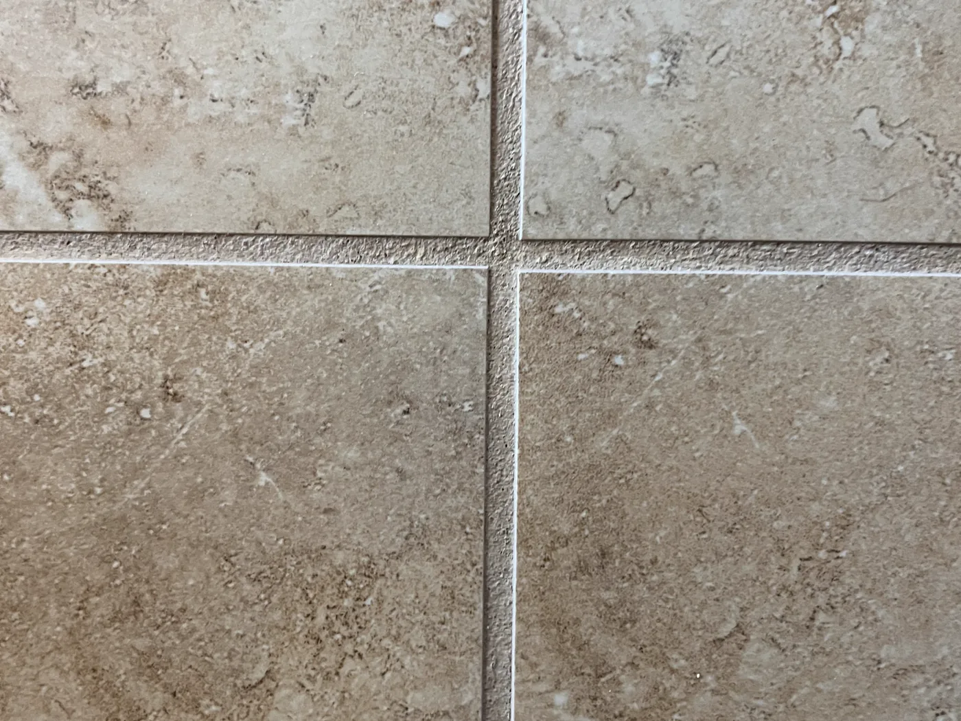 Travertine floor tile with evenly colored grout joints after color sealing