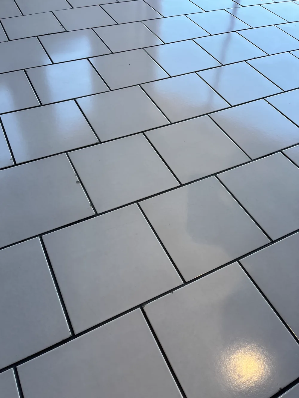 Light commercial tile floor with dark grout joints cleaned to an even tone