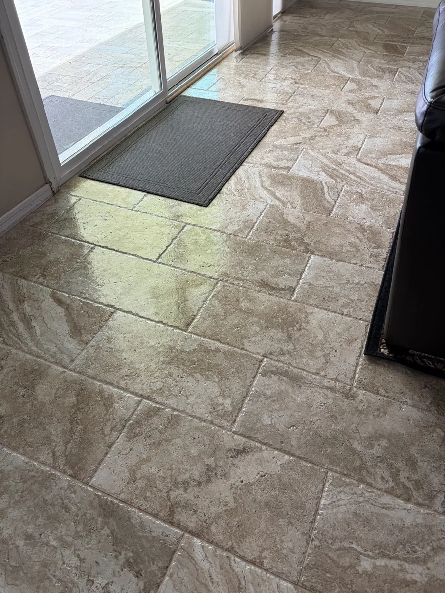 Filled cross-cut travertine floor continuing through an open residential room