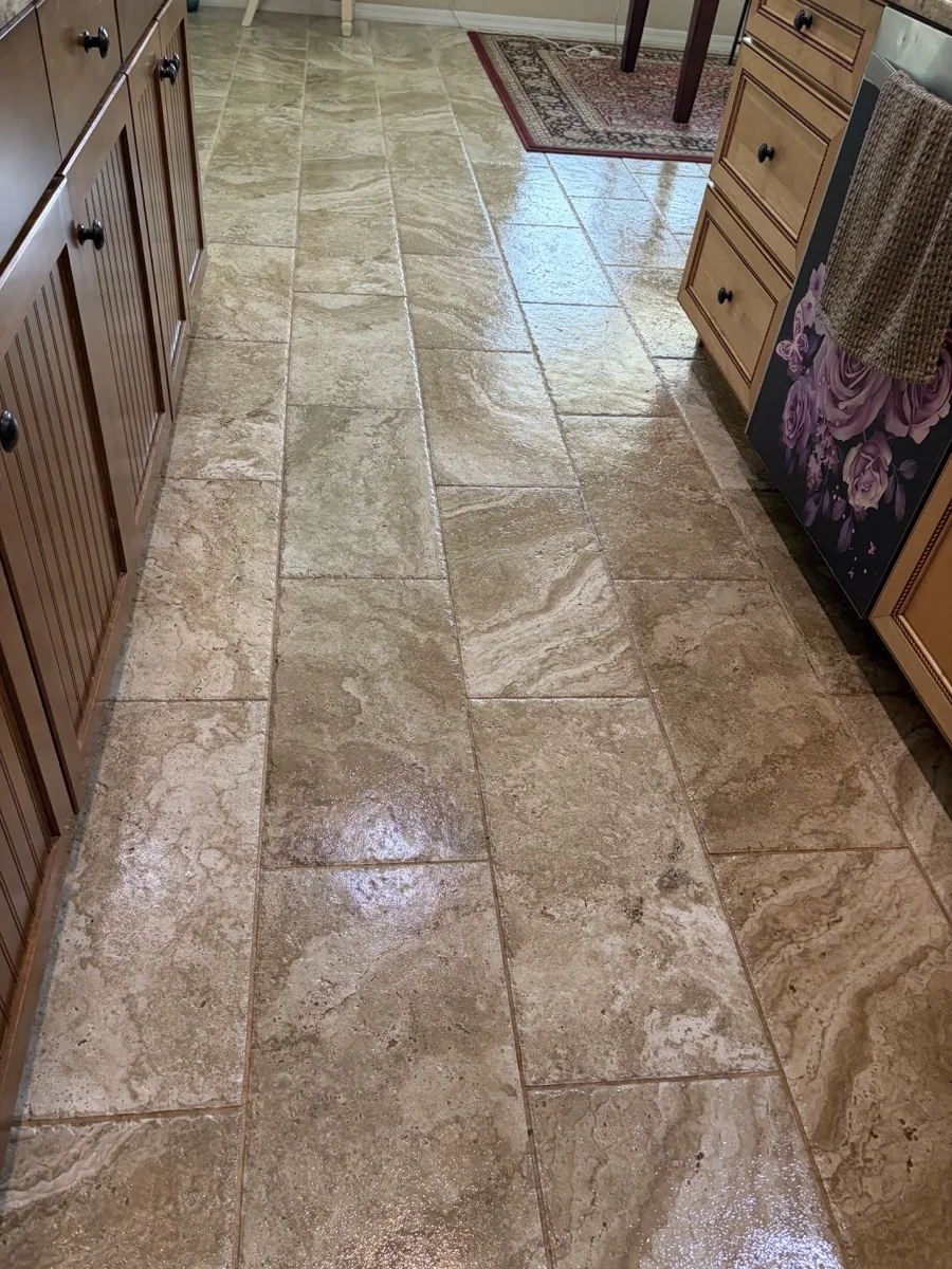 Filled cross-cut travertine floor running through a residential kitchen and connected room